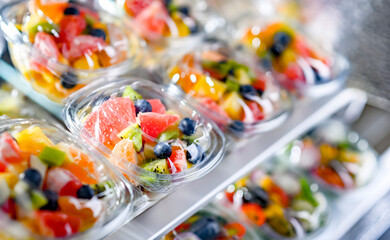 Boxes with pre-packaged fruit salads in a commercial fridge
