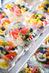 Boxes with pre-packaged fruit salads in a commercial fridge