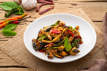 Spicy Stir Fried Frog meat with chilli paste and basil leave on white plate