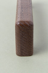 Wooden furniture handle on green background. Handle-bracket. Wood texture closeup