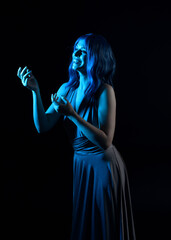  close up portrait of pretty girl with blue hair wig & elegant gown with expressive facial expressions & gestural arm poses. colourful neon gel lighting, isolated on studio background.