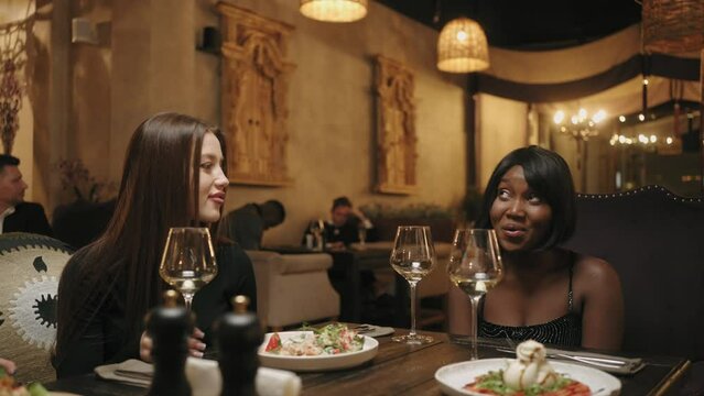 female friends meeting in restaurant in weekend, have dinner and talking cheerfully, secret party