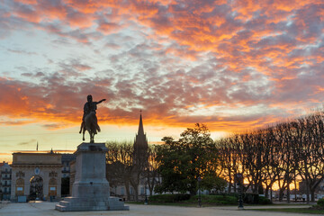 Fototapeta premium Colorful winter sunrise landscape with Louis XIV equestrian statue and arch of triumph at Promenade du Peyrou public park, Montpellier, France
