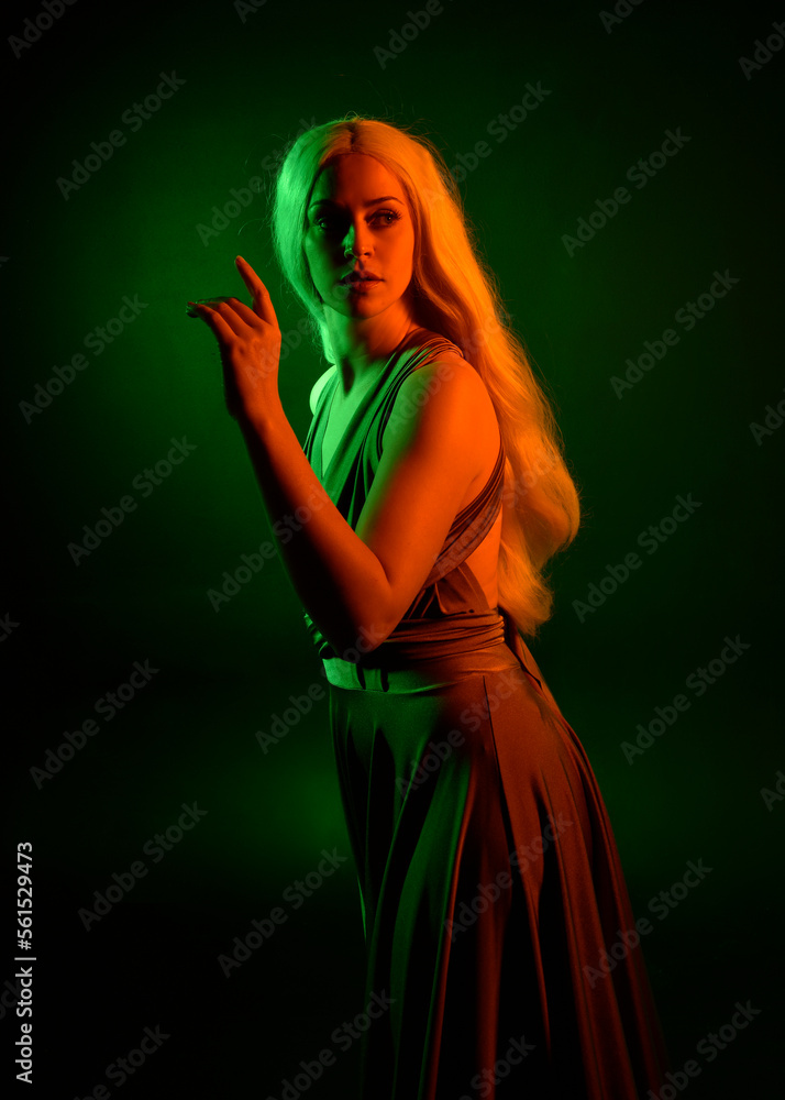 Poster portrait of pretty girl with blonde hair & elegant gown with expressive facial expressions & gestural arm poses. colourful neon gel lighting, isolated on black studio background.