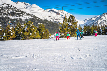 Ski instructor teaching a group of young kids how to ski in El Tarter green slope. Winter holidays...