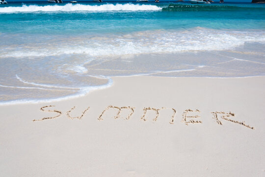 the word summer written on the white sand