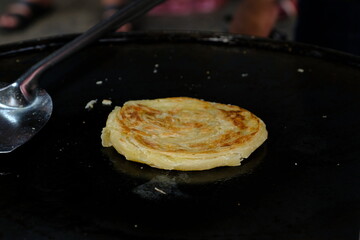 Making of Roti Canai or Roti Prata or Roti India in a festival food, traditional pancake for breakfast from Thailand, Indonesia, Singapore or Malaysia