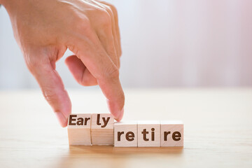 Hand man tuning wooden cube with wording early retire, Monney saving concept