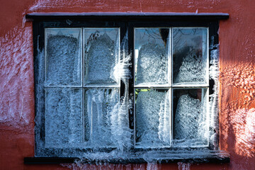 Window with ice and icicles in the winter