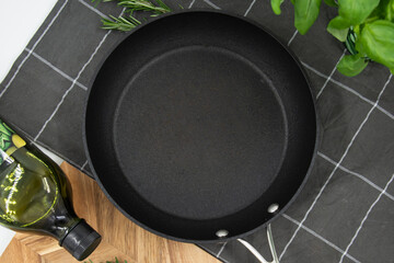 Empty cast iron frying pan on white culinary background, view from above