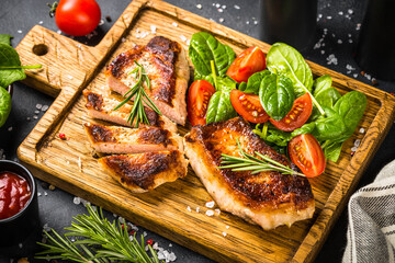 Meat steaks with fresh salad served at wooden served board. Keto diet food. Close up