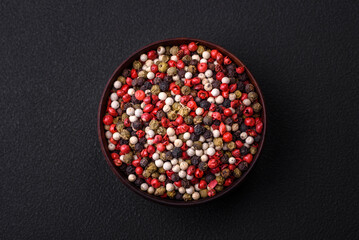 Allspice peas in a wooden bowl on a black concrete background