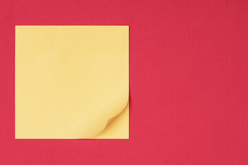 Yellow sticky note on red background waiting for your message