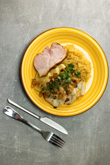pork meat with potato dumplings and pickled cabbage served with roasted onion