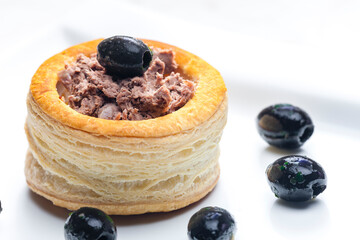 puff pastry filled with terrine served with black olives