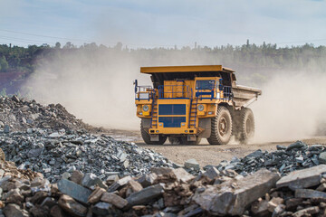 Large dump truck for removal of rock mass from the quarry for open-pit mining of minerals. Initial stage of melalurgy, machinery for the extraction of raw ore.