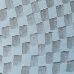 blue-gray construction paper with black ink squarish markings