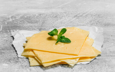 Thin slices of cheese with a branch of mint.