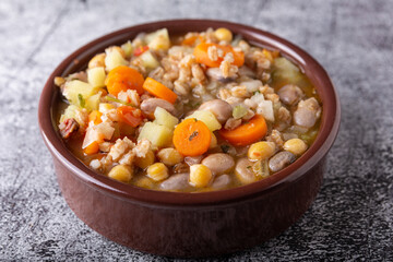 Spelled and legume soup served on an earthenware plate. Single balanced dish, suitable for a vegan diet, rich in vitamins, minerals and iron.