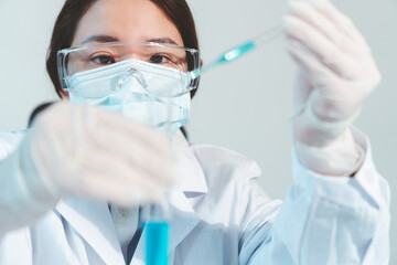 Asian woman Scientist experimental in laboratory with test tube and beaker for medical research