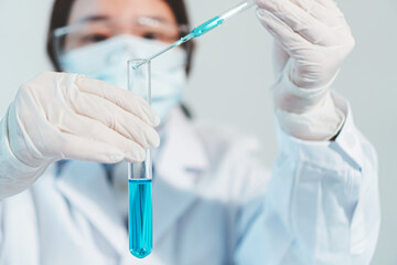 Asian woman Scientist experimental in laboratory with test tube and beaker for medical research