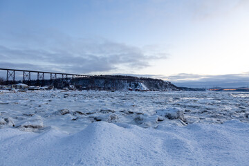 Pretty view of the St. Lawrence river, the 1908 railway trestle bridge and the Cap-Rouge bay seen during a blue hour winter morning, Quebec City, Quebec, Canada 