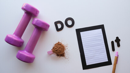 Mancuernas moradas y prote&iacute;na en polvo en un fondo blanco y negro con mensaje para motivar, do it