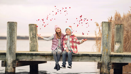 zwei Kinder werfen Rosenblüten in die Luft