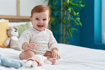 Adorable redhead toddler smiling confident sitting on bed at bedroom