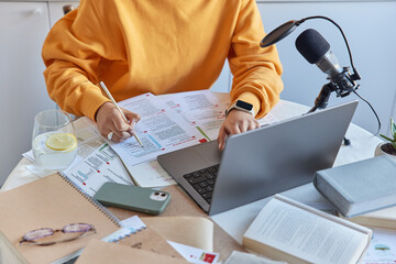 Cropped shot of unknown female student uses laptop for searching information does exercises in...
