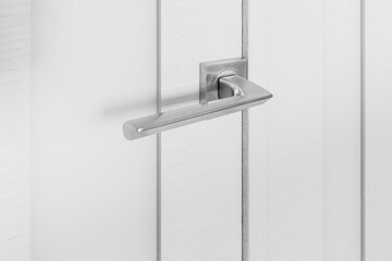 Detail of a metallic knob on white door horizontal