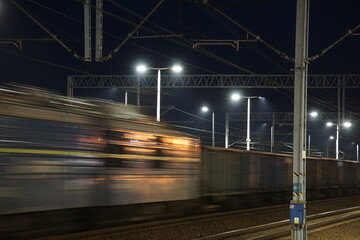 Pociąg towarowy w czasie jazdy po torach kolejowych nocną porą