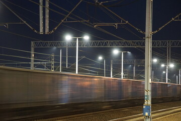 Pociąg towarowy w czasie jazdy po torach kolejowych nocną porą - obrazy, fototapety, plakaty