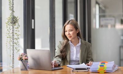 portrait of business Asian woman Accounting using calculating income-expenditure and analyzing real estate investment data report Financial and tax systems concept.	