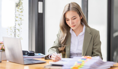 portrait of business Asian woman Accounting using calculating income-expenditure and analyzing real estate investment data report Financial and tax systems concept.	