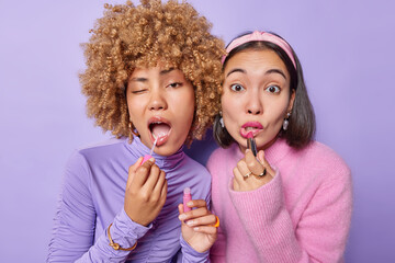 Photo of young multiracial women apply lipstick and lipgloss want to look beautiful get prepared...