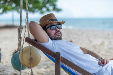 Asian man sitting chair beach inside sea,Relax time at summer
