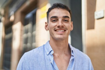 Obraz premium Young hispanic man smiling confident standing at street