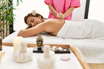Obraz na płótnie Canvas Young latin woman having back massage session