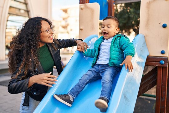 Mother and son playing on slide at park