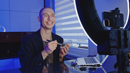 Male makeup artist teaching his social media followers on how to apply cosmetic . High quality photo