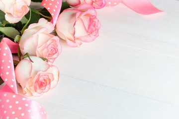 Pink roses with polka dots ribbon on white wood close up for Valentine's day, Mother's day, Wedding.
