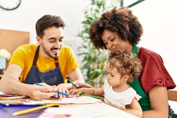 Couple and daughter smiling confident drawing at art studio