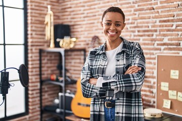 African american woman musician smiling confident standing with arms crossed gesture at music studio