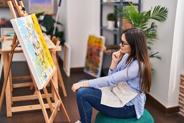 Young woman artist looking drawing at art studio