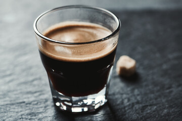 Coffee in glass cup on dark stone background. Close up.