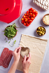 Making of mini pizzas in a heart shape for Valentines day holiday.