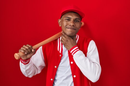 Young hispanic man playing baseball holding bat touching painful neck, sore throat for flu, clod and infection