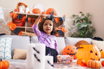 Fototapeta premium Adorable hispanic toddler having halloween party standing at home