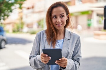 Young woman executive smiling confident using touchpad at street
